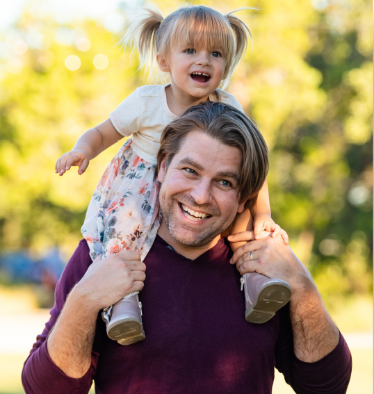 smiling girl on man's shoulders